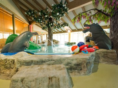Kinderbecken mit Delfin- und Bärenfigur sowie Spielzeugen.