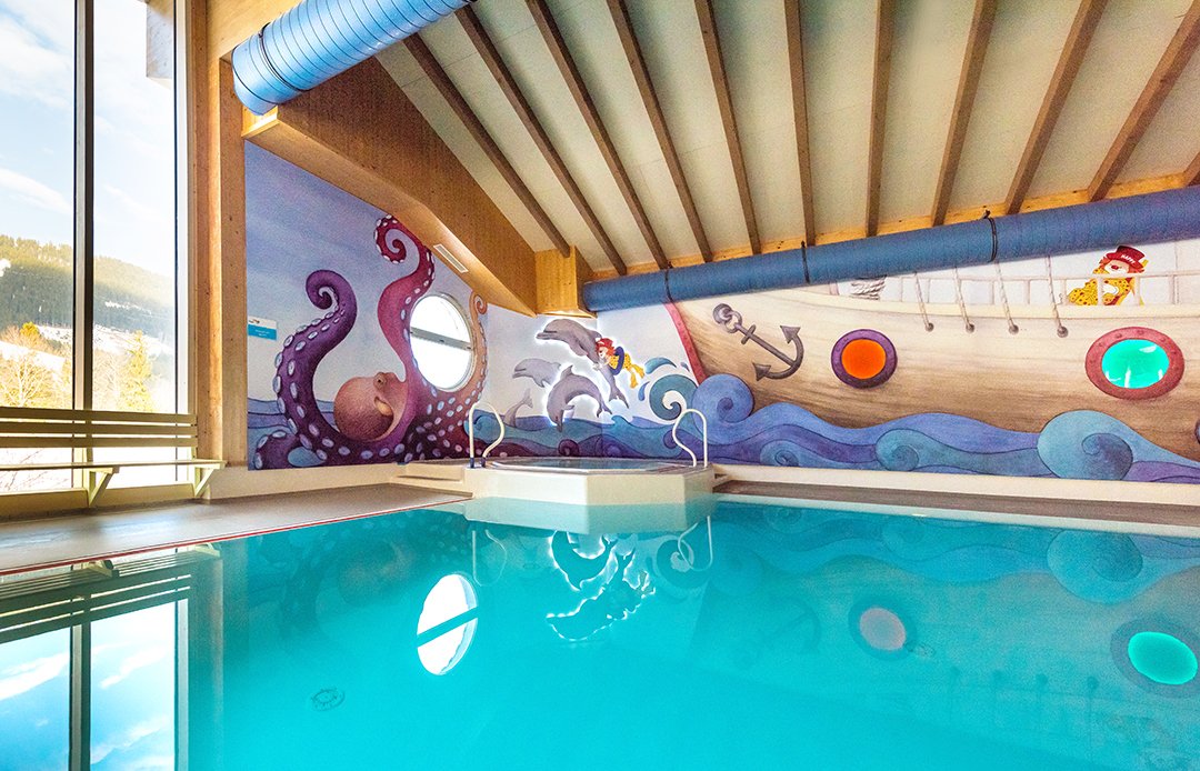 Innenansicht eines Pools mit maritimem Wanddesign und Piratenmotiv.