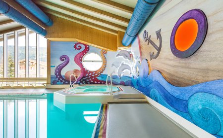 Innenansicht eines Pools mit maritimem Wanddesign, das Kraken, Wellen und einen Anker zeigt.