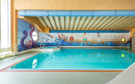Innenaufnahme eines Pools mit einem maritimen Wandbild und einem Schiffsdesign.