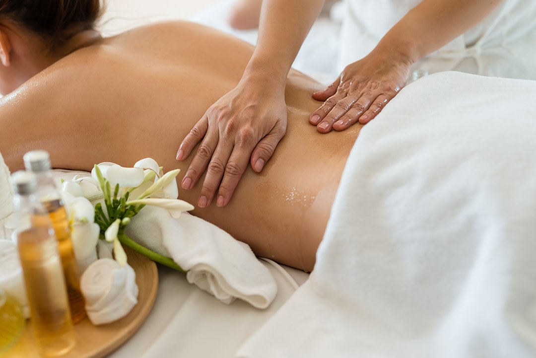 Eine Frau erhält eine entspannende Rückenmassage mit ätherischen Ölen in einem Spa.