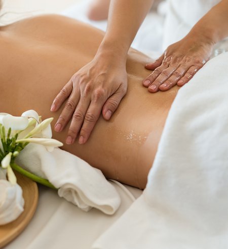 Eine Frau erhält eine entspannende Rückenmassage mit ätherischen Ölen in einem Spa.