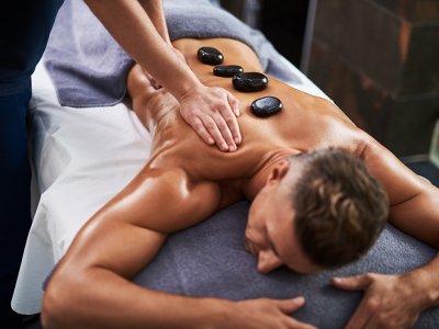 Ein Mann erhält eine heiße Steinmassage in einem Spa.