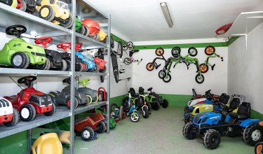 Spielzeugfahrzeuge sind auf Regalen und dem Boden eines Raumes verstaut.