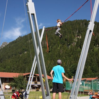 Ein Kind schwingt an einem Hochseilgarten.