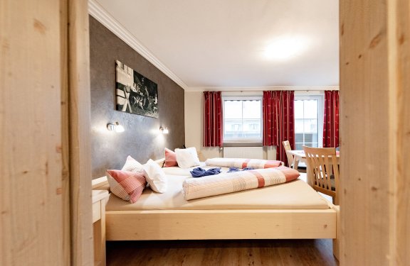 Blick ins Schlafzimmer mit Doppelbett und Balkon.