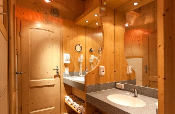 Badezimmer aus Holz und mit Bodenfliesen mit zwei Waschbecken.
