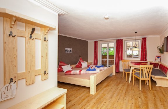 Großzügiges Doppelzimmer mit Garderobe, Sitzecke und Balkon.