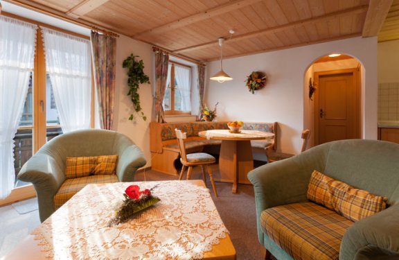 Wohnzimmer mit Tisch, Sesseln und Fensterbank.