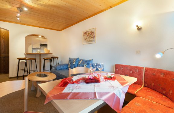 Heller Wohnbereich mit gemütlicher Sitzecke, Sofa, 4 Barhocker zur Durchreiche der Küche.